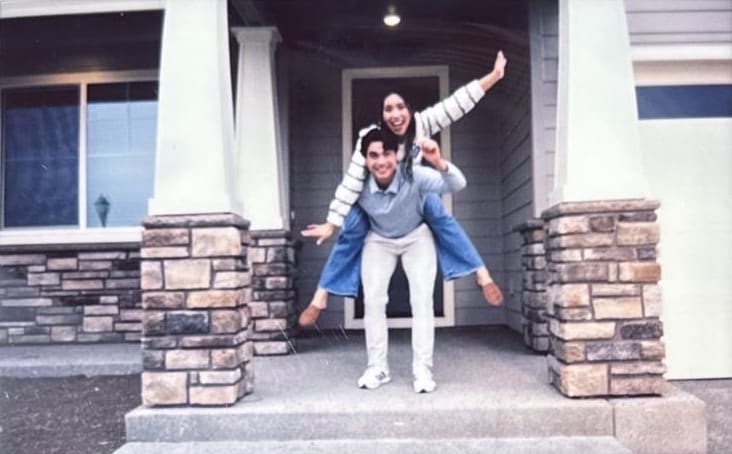 A couple celebrating in front of their first home